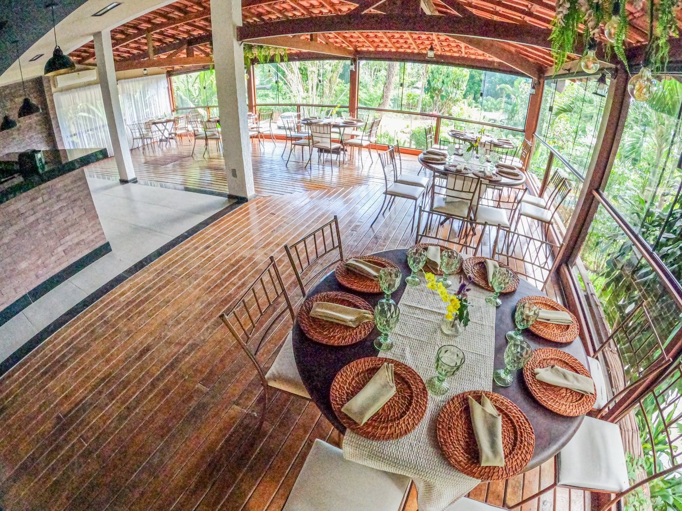 Salão coberto do espaço de eventos com vista para a mata